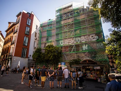 Unos turistas escuchan a un guía ante los murales de Puerta Cerrada en La Latina, llenos de grafitis este viernes.