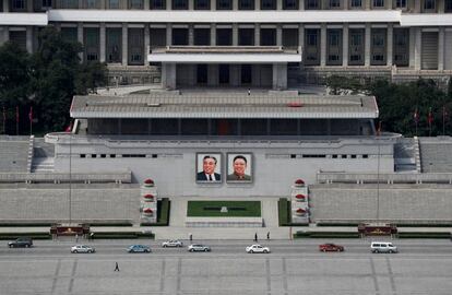 O tráfego circula perante os retratos dos últimos líderes norte-coreanos, Kim Il Sung e Kim Jong Il, na praça principal Kim Il Sung, em Pyongyang.