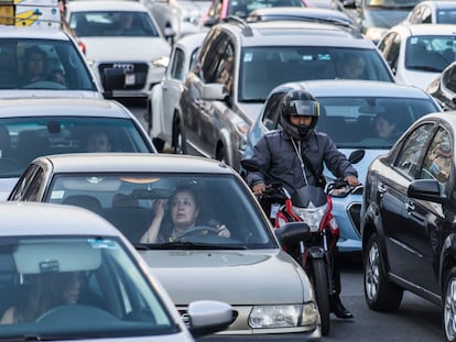 Una automovilista se maquilla mientras espera que cambie el semáforo, en Ciudad de México, en abril de 2022.