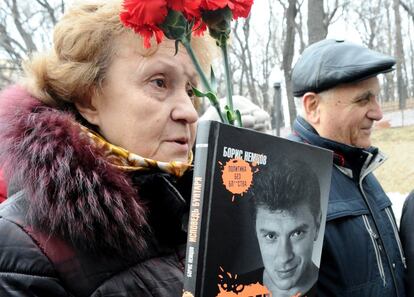 Una mujer sujeta junto a un ramo de flores una biografía de Boris Nemtsov, titulada 'Confesiones de un rebelde", en un momento del funeral del fallecido opositor ruso, este martes en Moscú.
