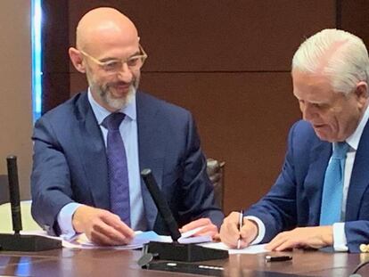 Enrique Sánchez, secretario de la Junta Directiva del Real Madrid, y Eduardo García, abogado de Clifford Chance, firmando el acuerdo de financiación de las obras del estadio.