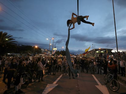 Un hombre hace acrobacias colgado de un puente durante una protesta en Bogotá, el 27 de noviembre de 2019.