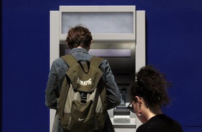 Varios usuarios esperan a sacar dinero de un cajero.