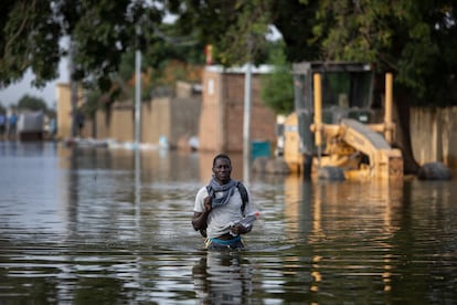Un vecino del barrio de Walia, en Yamena, capital de Chad, camina en el agua por una de las calles inundadas.