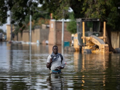 Un vecino del barrio de Walia, en Yamena, capital de Chad, camina en el agua por una de las calles inundadas.