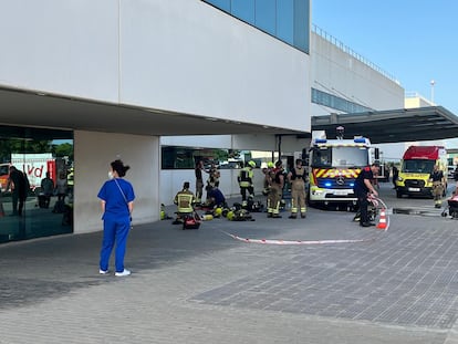 Un grupo de bomberos y una sanitaria este lunes en el exterior del hospital La Fe de Valencia.
