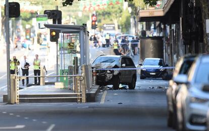 Un todoterreno blanco en medio de la carretera mientras un grupo de policías llevan a cabo la investigación del atropello en Flinders Street, Melbourne (Australia).