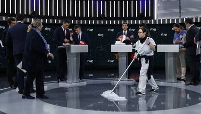 Una mujer de la limpieza abrillanta el suelo mientras los candidatos se preparan para el debate.