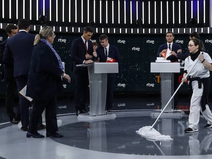 Una mujer de la limpieza abrillanta el suelo mientras los candidatos se preparan para el debate.