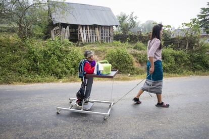 La carencia de oxígeno al nacer provocó en Kum una discapacidad intelectual y física. Su familia lucha cada día en la aldea de Phonxay, al norte de Laos, porque el pequeño lleve una vida normal y tenga un futuro. En la imagen, la madre de Kum le lleva al colegio en un carrito, en septiembre de 2019.