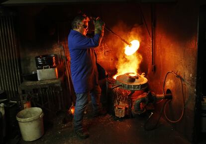 Serge Huguenin quita la tapa del horno durante la preparación de las campanas en la fundición Blondeau.