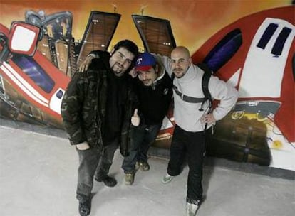 Los grafiteros Antonio, Roberto y David junto a su creación <i>Metro. La montaña rusa</i>.