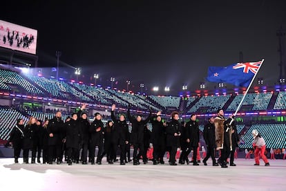 O porta-bandeira da delegação da Nova Selândia, Beau-James Wells, e seus colegas chegam ao estádio de Pyeongchang.