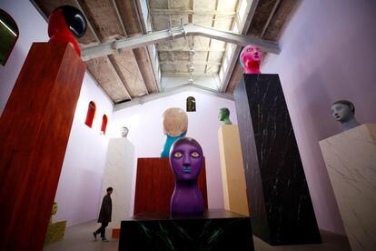 Un visitante pasa junto a varias obras del artista suizo Nicolas Party que forman parte de su muestra 'Arcos' en la galería M Woods de Pekín (China).