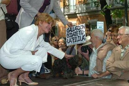 Carmen Thyssen acaricia al perro de uno de los manifestantes que acudieron a la concentración en el bulevar del paseo del Prado.