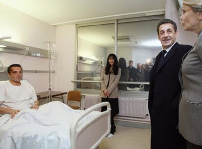 El presidente francés, Nicolas Sarkozy, visita en el hospital de Eaubonne al comisario de la policía gala herido tras los disturbios de la noche del lunes.