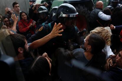 Policiais tentam chegar a uma mesa de votação em Girona.