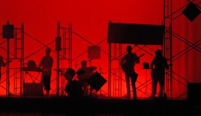 Músicos tocando en directo con un fondo rojo