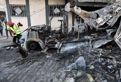 Un hombre limpia los restos de la furgoneta bombardeada por el ejército israelí donde han muerto cinco periodistas de la cadena Al Quds, este jueves en Nuseirat. 