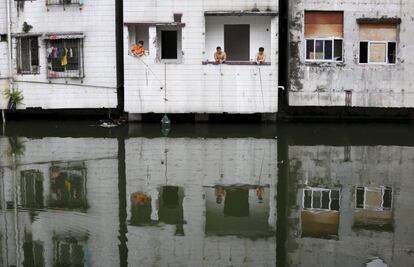 Vecinos pescando desde las ventanas de su casa en el pueblo de Xian, un barrio pobre en el centro de Guangzhou, China