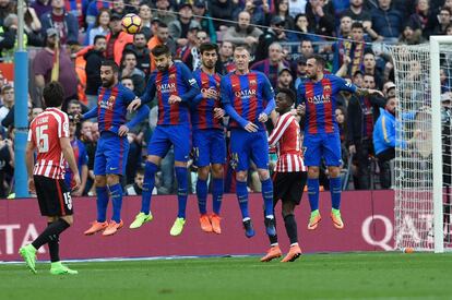 Los jugadores de Barcelona tratan de detener el balón en el lanzamiento de una falta.