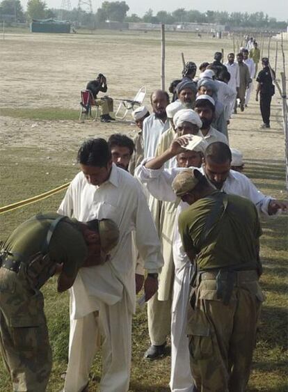 Soldados paquistaníes registran a civiles que huyen de Waziristán del Sur.