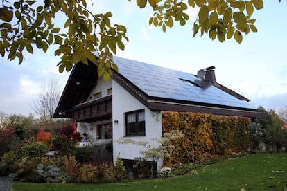 Placas solares en el tejado de una casa unifamiliar. El proyecto se integra tanto en el entorno urbano como en el rural.