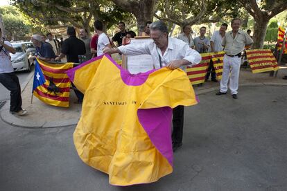 Un hombre, con un capote, en la puerta del parlamento catalán, antes de la votación que ha abolido los toros en Cataluña.