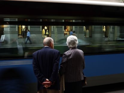 Una pareja de jubilados mira un autob&uacute;s pasar en una calle de Madrid