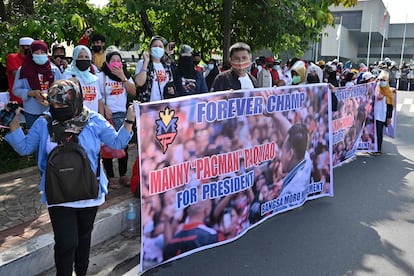 La multitud aclama a Manny Pacquiao con pancartas donde se lee "campeón eterno" y "Manny presidente", en Manila, el 1 de octubre de 2021.