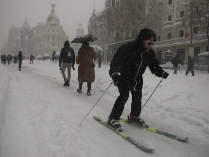Varios jóvenes se deslizan con esquís por la calle de Alcalá de Madrid, este sábado.