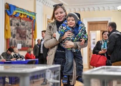 Una mujer, acompañada de su hijo, ejerce su derecho al voto en Kiev.