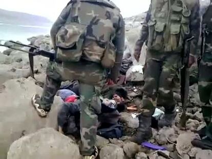 Militares junto a supuestas víctimas de la represión en Homs, en una imagen de vídeo.