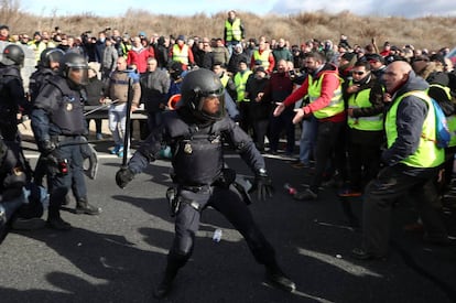 Police clash with striking taxi drivers as they try to block the M-40 road in Madrid.