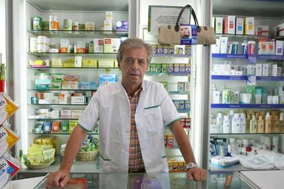 Ambrosio, dueño de la farmacia El Pilar, en Valencia, posa detrás del mostrador.