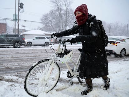 A woman moves along Harlem Avenue on her way to work, as a winter storm hits the Chicago area with heavy snow and near-blizzard conditions, on January 12, 2024.