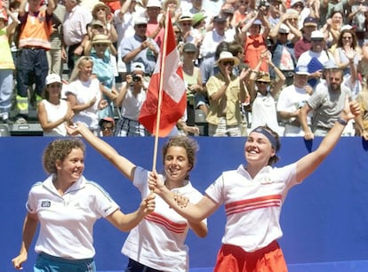 Las jugadores del Equipo suizo en la Copa Federación: Patty Schnyder (I), Emmanuelle Gagliardi (C), y Martina Hingis, enarbolando su bandera nacional celebrando su victoria en semifinales contra Francia, en Sion, el 26 de julio de 1998.