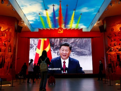 Visitantes frente a una pantalla gigante que muestra al presidente chino, Xi Jinping, junto a una bandera del Partido Comunista de China, en el Museo Militar de la Revolución Popular China en Pekín, el pasado 8 de octubre.