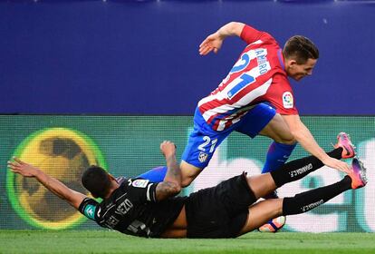 El jugador francés del Atlético de Madrid Kevin Gameiro defiende la pelota ante Tito, jugador del Granada.