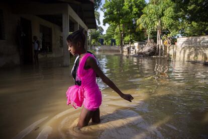 Una niña camina hacia su casa inundada un día después del paso de 'Laura', en Puerto Príncipe Haití.