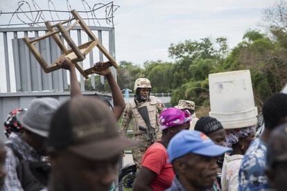 Un miembro del Cuerpo Especializado en Seguridad Fronteriza (CESFRONT) abre las puertas que separan República Dominicana de Haití para permitir el cruce al Mercado Fronterizo en Dajabón.