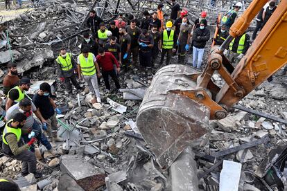 Rescatistas y civiles tratan de hallar supervivientes entre los escombros, este domingo en Almat (Líbano), tras un bombardeo israelí.