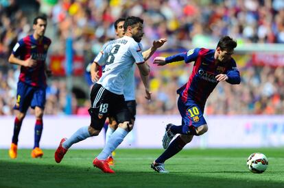 Messi conduce el balón perseguido por Javi Fuego.
