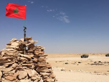 Vehículos del Ejército marroquí pasan ante una bandera de Marruecos, en la zona del Guerguerat, próxima a la frontera con Mauritania, el pasado noviembre.