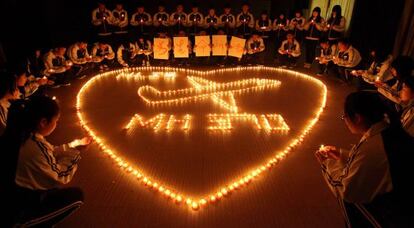 Estudiantes de un colegio en la ciudad china de Zhuji rezan por los pasajeros extraviados en el vuelo MH370.