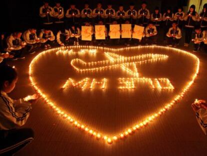 Estudiantes de un colegio en la ciudad china de Zhuji rezan por los pasajeros extraviados en el vuelo MH370.