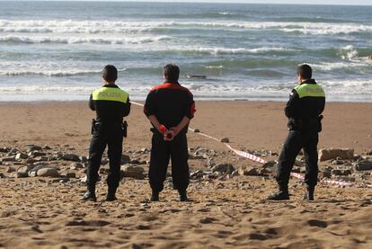 Un <b><i>ertzaina, </b></i>junto con dos policías locales, durante un operativo en una playa vizcaína.