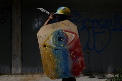 Un manifestante sostiene un cuchillo y su escudo pintado a mano, mientras posa para un retrato. 'La situación es muy dura y tenemos hambre. De verdad que necesitamos un cambio'.