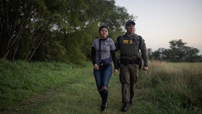 Un agente de la patrulla fronteriza detiene a una migrante de El Salvador en Texas, en junio de 2024.