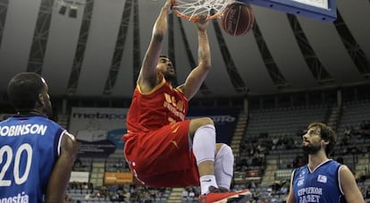 El brasileño de UCAM Murcia  machaca la canasta ante los jugadores del Gipuzkoa Basket, Jason Robinson, a la izquierda, y Doblas.